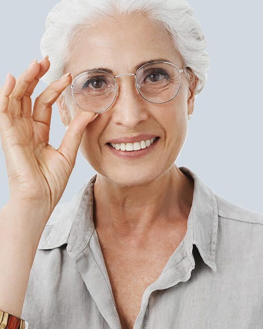 Smiling patient adjusting her glasses